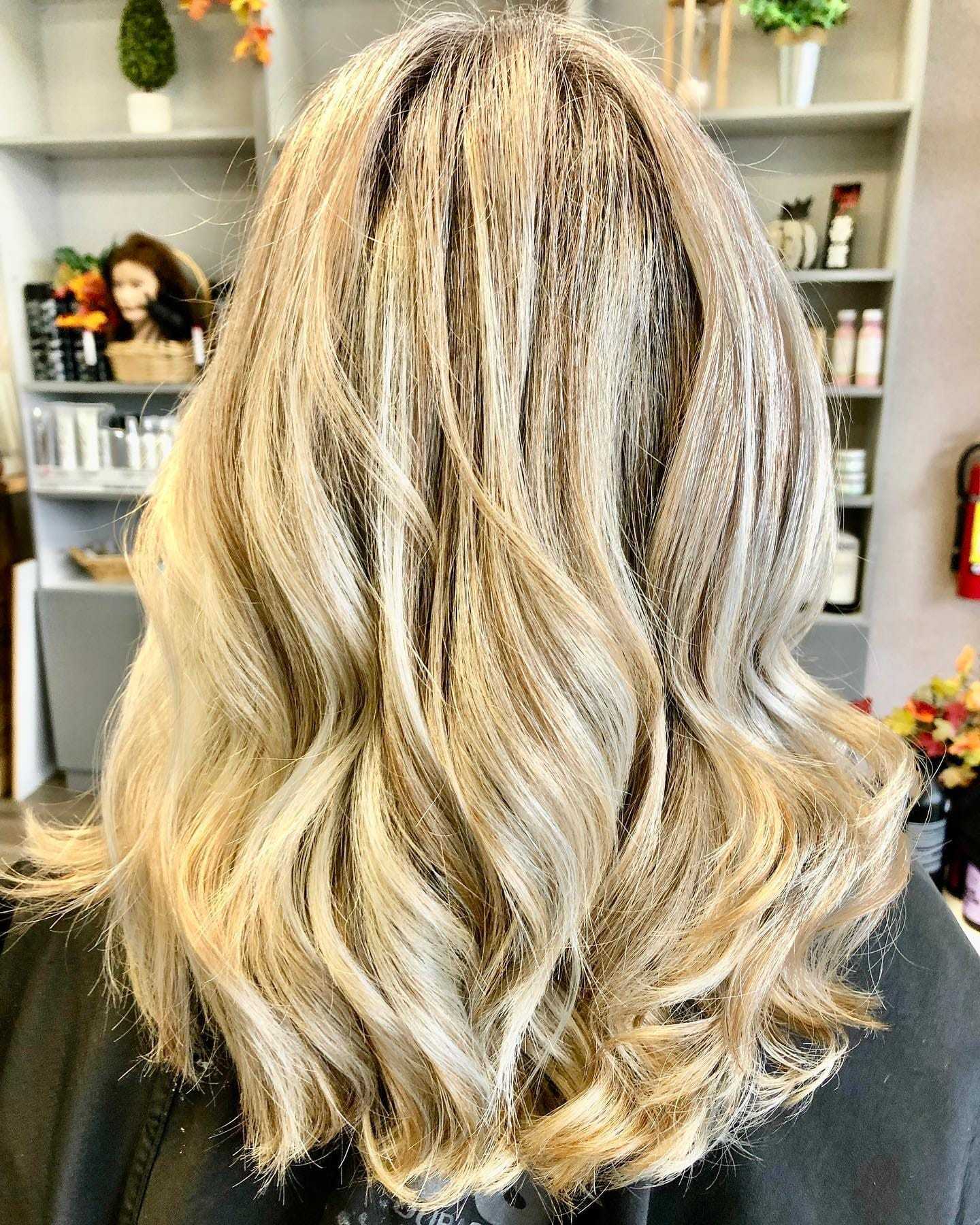 Blonde hair with soft waves in a salon setting.
